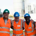 Groupe de personnes portant un gilet orange et un casque de sécurité sur un site minier